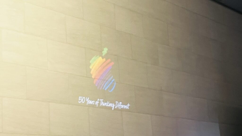 壁に投影されているAppleのロゴと50years of Think Different の文字